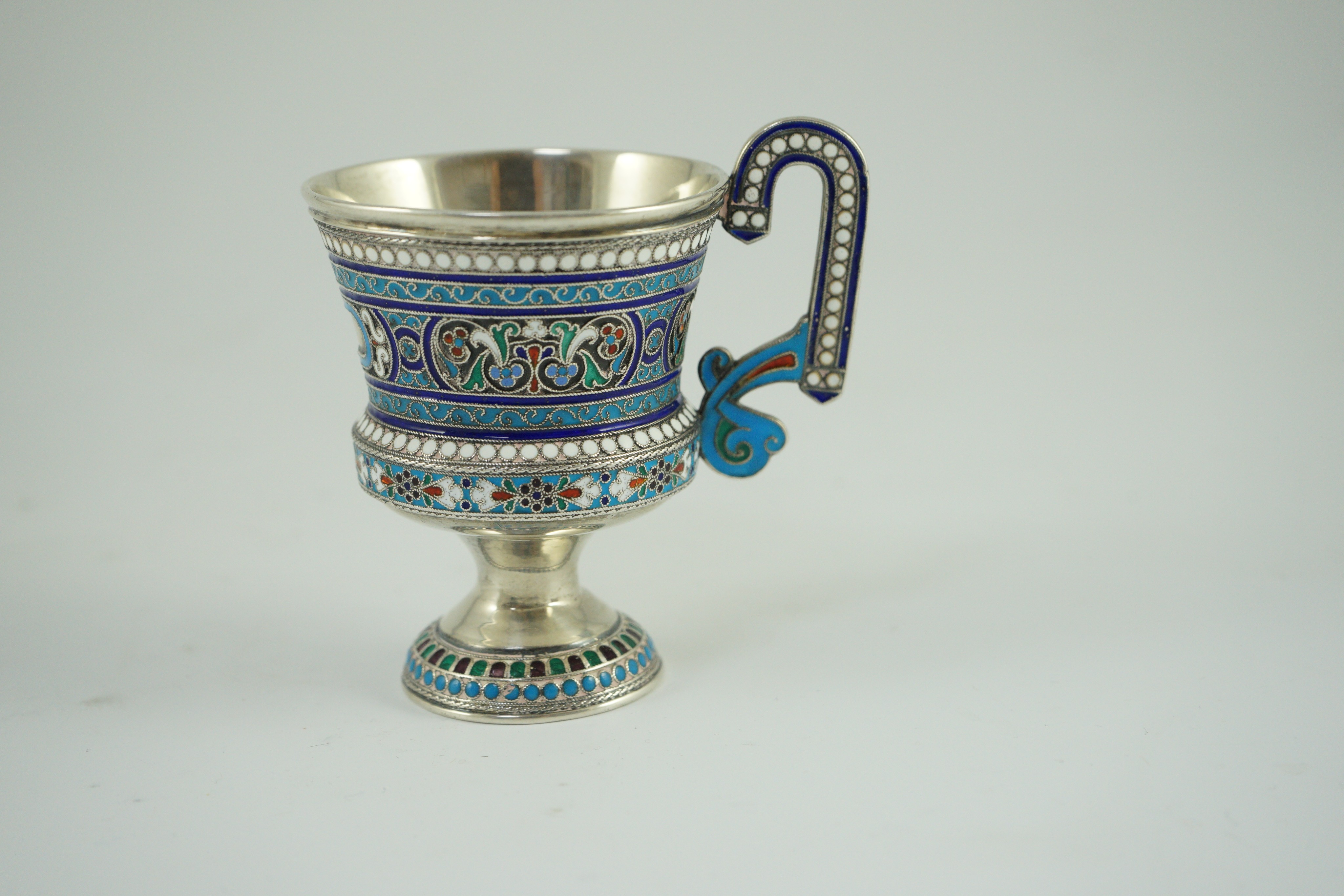 An early 20th century Russian 84 zolotnik and polychrome cloisonné enamel pedestal mug